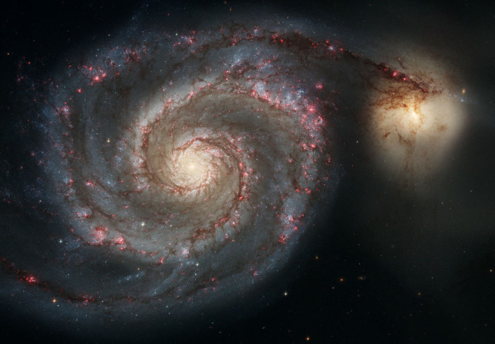 Когато малка галактика преминава зад по-голяма спираловидна.